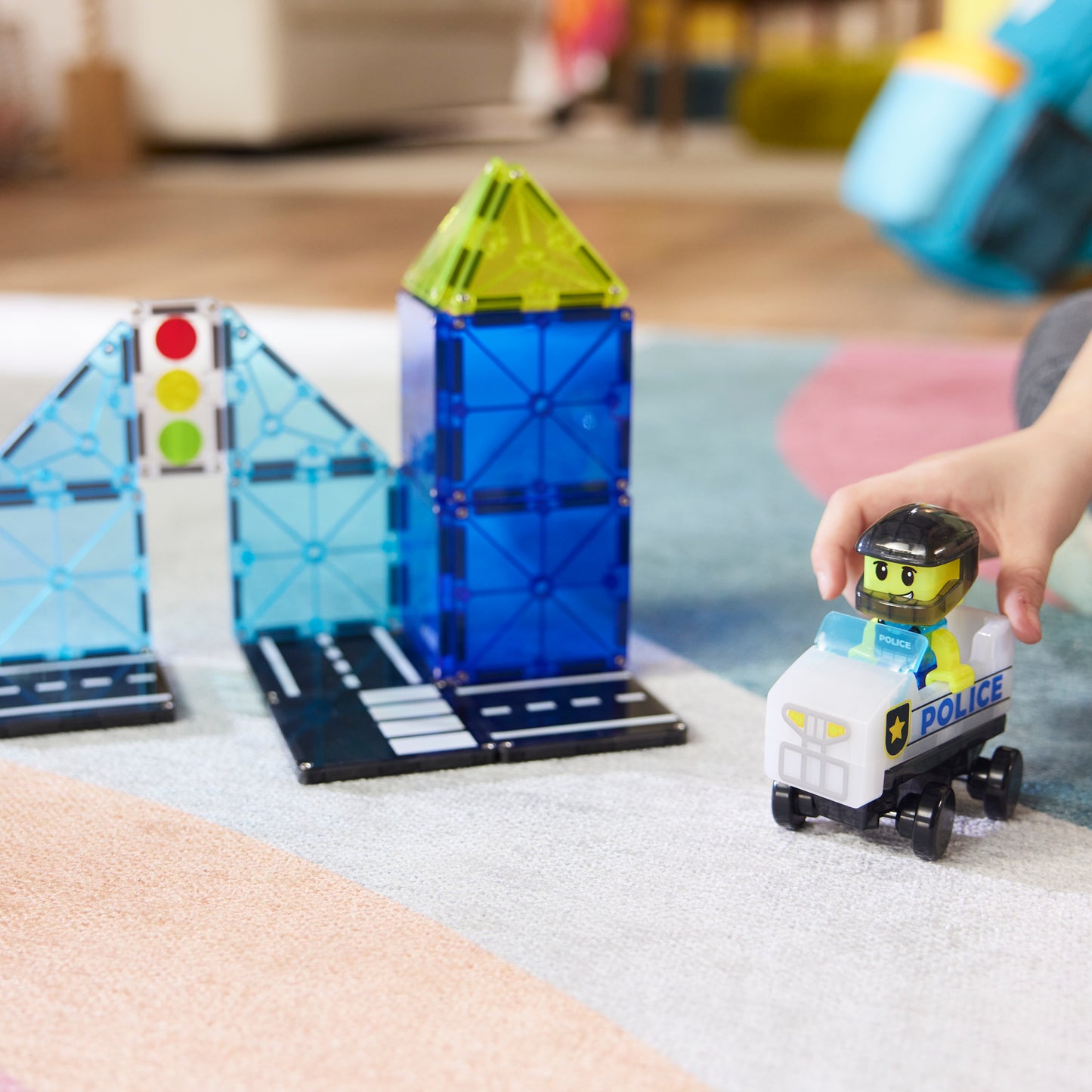 Kind speelt met magnetic magna tiles Police Station politieauto en blauwe magnetische tegels
