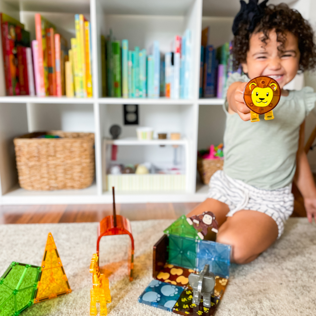 Magnetic magna tiles Safari Animals kind speelt met magnetisch speelgoed leeuw en aap in kinderkamer