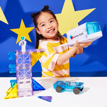 Meisje speelt met magnetic magna tiles Space raket en astronaut magnetisch speelgoed blauwe achtergrond