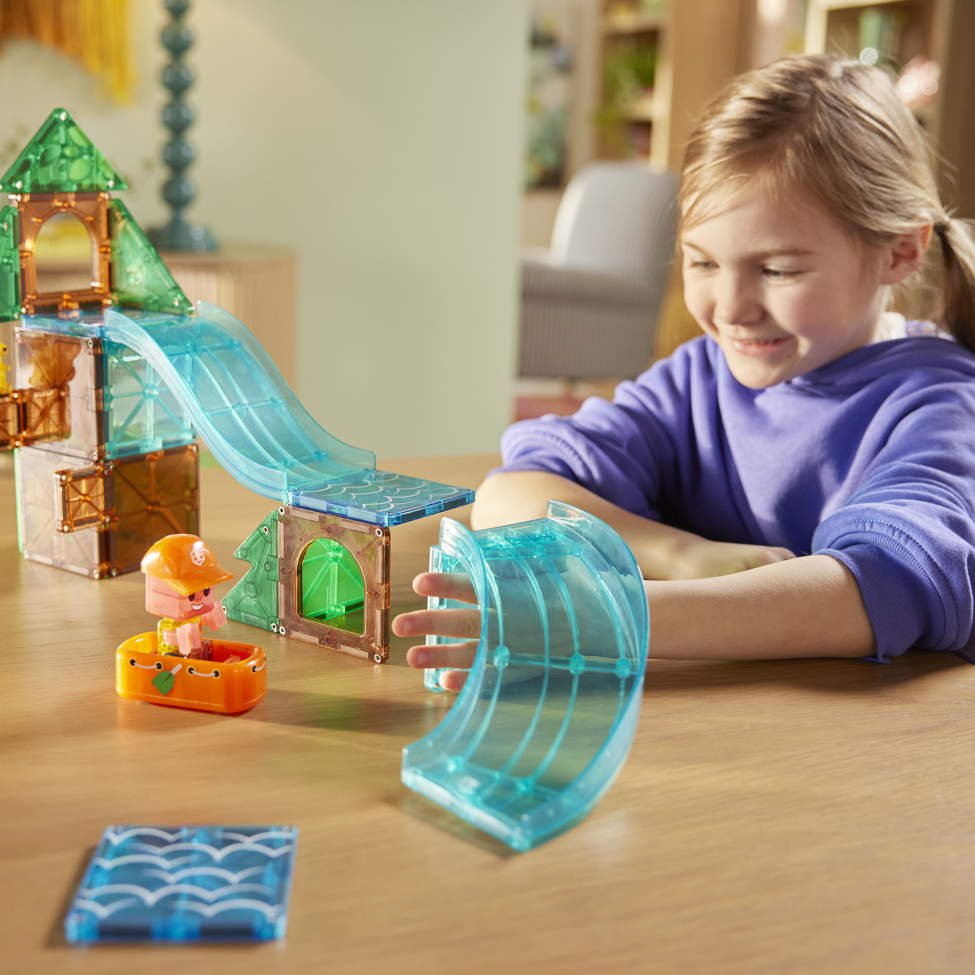 Magnetic magna tiles kind speelt met Raging Rapids wildwaterbaan, blauwe glijbaan en sensorisch speelgoed