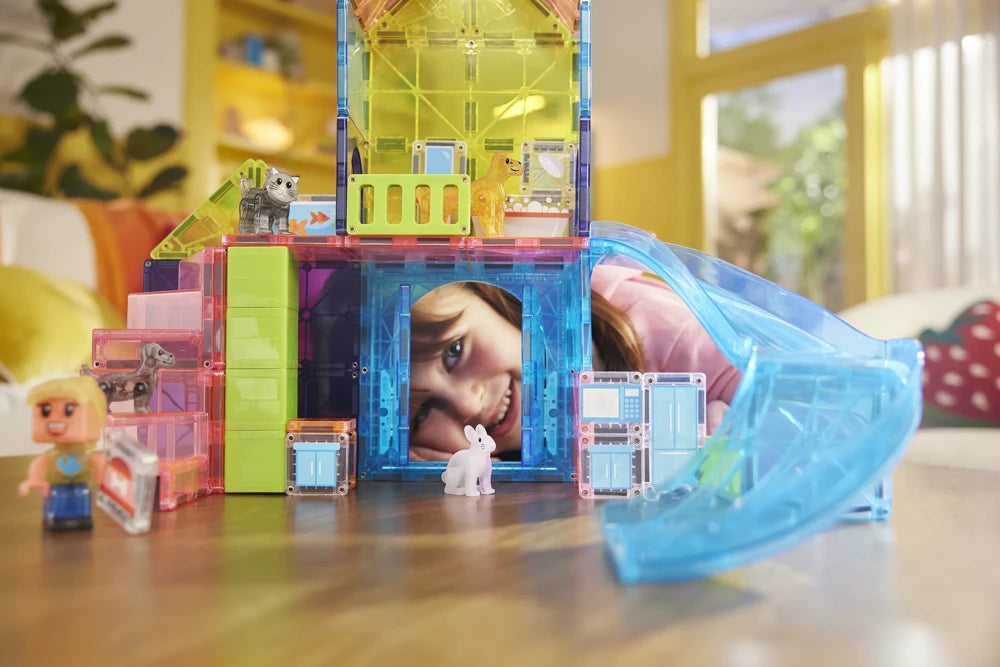 Kind kijkt door speelhuis van Magna Tiles Pet Playhouse met kat, hond, konijn en magnetisch speelgoedfiguur.