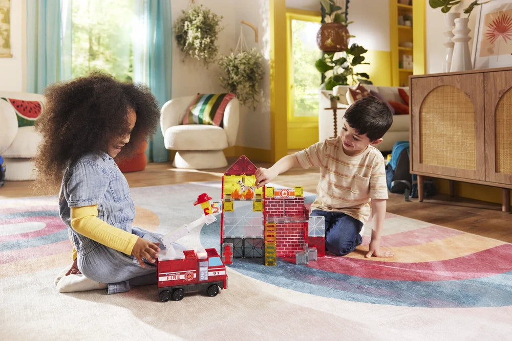Twee kinderen bouwen samen met 50 magnetische bouwstenen aan een Fire Station van magneet speelgoed.