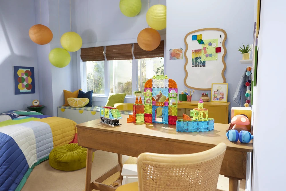 Kinderkamer met kleurrijke Magna Tiles bouwwerken uit de City Center set op houten speeltafel.
