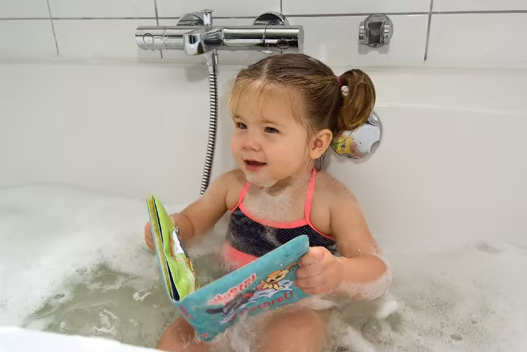 Kindje speelt in bad met Woezel en Pip badboekje Waterpret, vrolijk badboekje baby en leuk speelgoed voor in bad