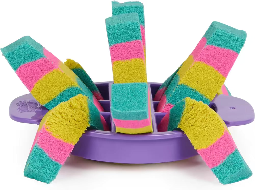 Gestreepte repen Kinetic Sand in paarse segmentmal met roze, geel en groen; kleurrijk sensorisch speelgoed detailfoto.