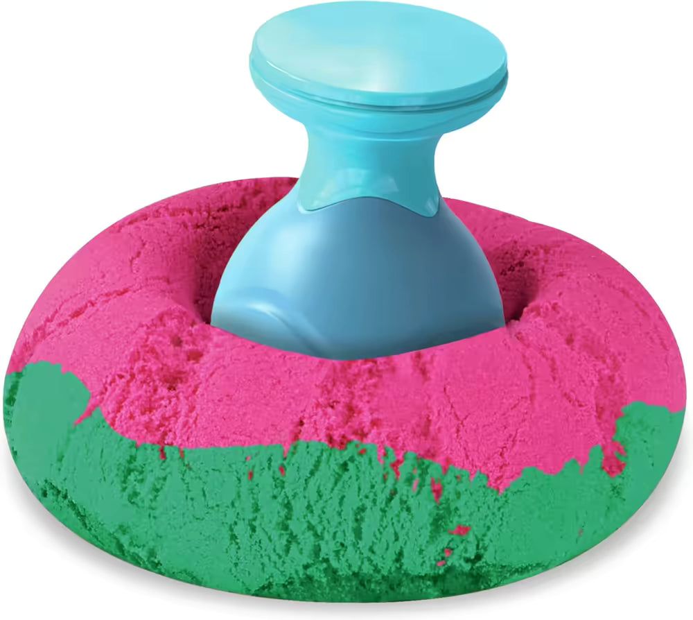 Blauwe stamper drukt patroon in roze-groen Kinetic Sand ring, toont textuur van sensorisch speelgoed duidelijk.