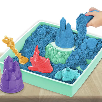 Bovenaanzicht van blauw kinetisch zand in sandbox set met kleurrijke mallen, ideaal educatief speelgoed voor kinderen.