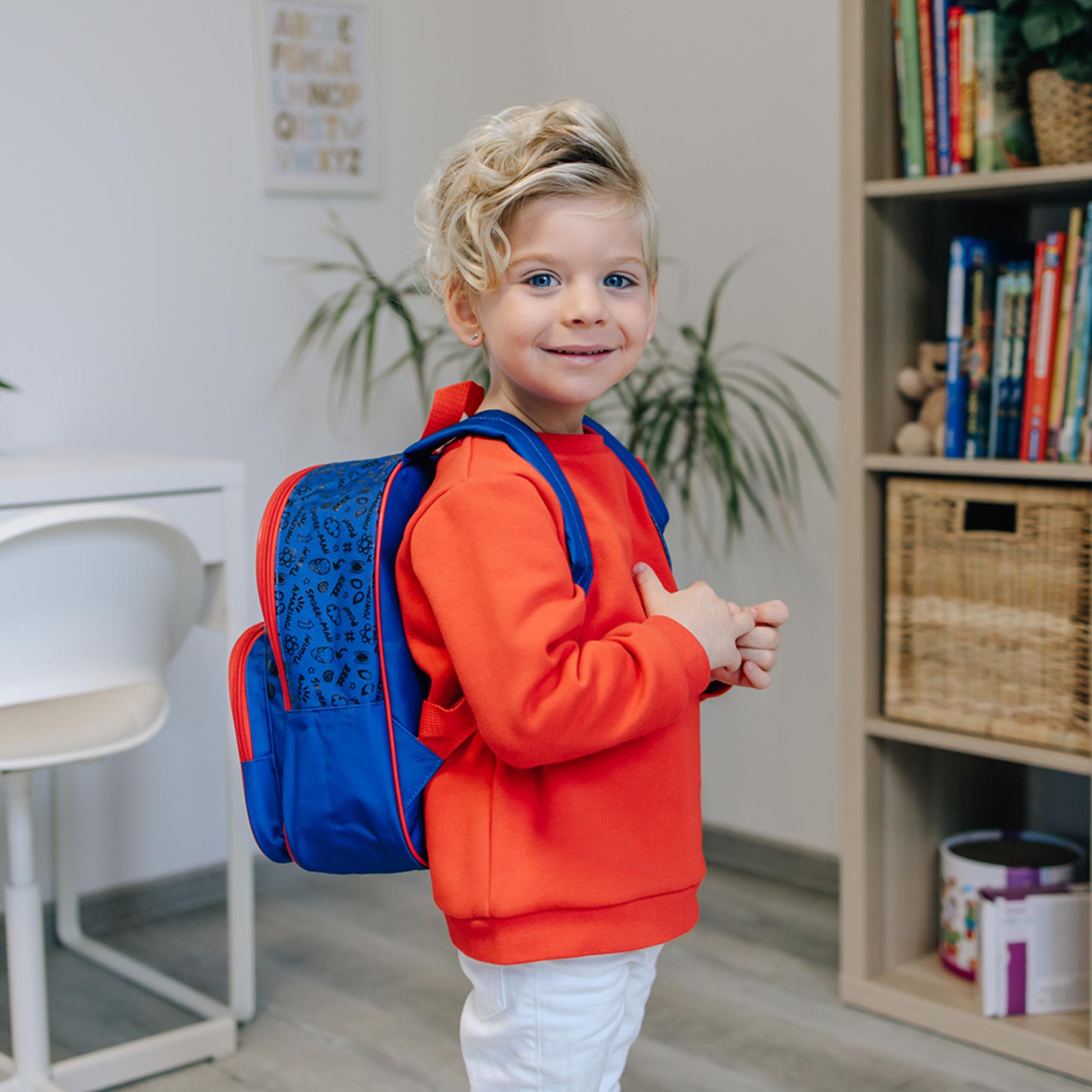 Kleine rugzak kinderen gedragen door peuter in oranje trui, blauwe Spiderman rugzak, back to school