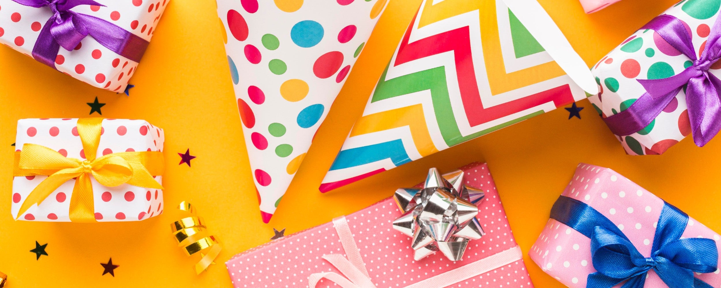 fel gekleurde ingepaktje cadeautjes met inpakpapier, feestmutsen van Sproutz. onderdeel van de speelgoed & Cadeauzoeker.