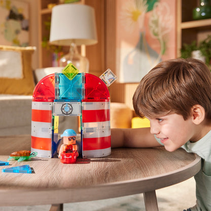 Jongen speelt met Lighthouse Rescue magneet speelgoed vuurtoren met gekleurde magnetische tegels