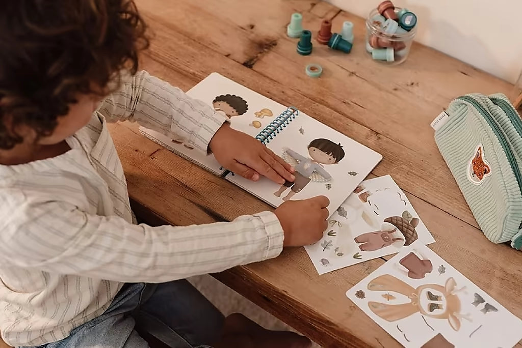 Kind speelt met Little Dutch aankleedboek Forest Friends aankleedboek, inclusief stickerset voor peuterboeken.