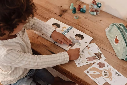 Kind speelt met Little Dutch aankleedboek Forest Friends aankleedboek, inclusief stickerset voor peuterboeken.