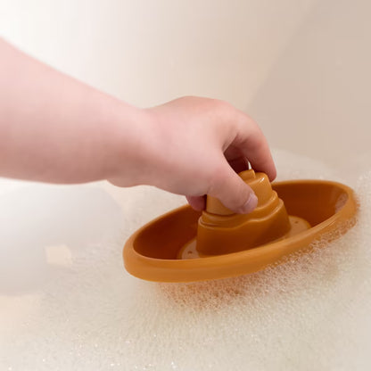 Kind speelt met geel Little Dutch Bad Bootje in schuimbad, vrolijk badspeelgoed voor peuters en kleuters.