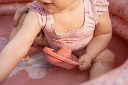 Baby speelt met Little Dutch Bad Bootjes Roze in een kinderbadje, ideaal badspeelgoed voor kleine kinderen.