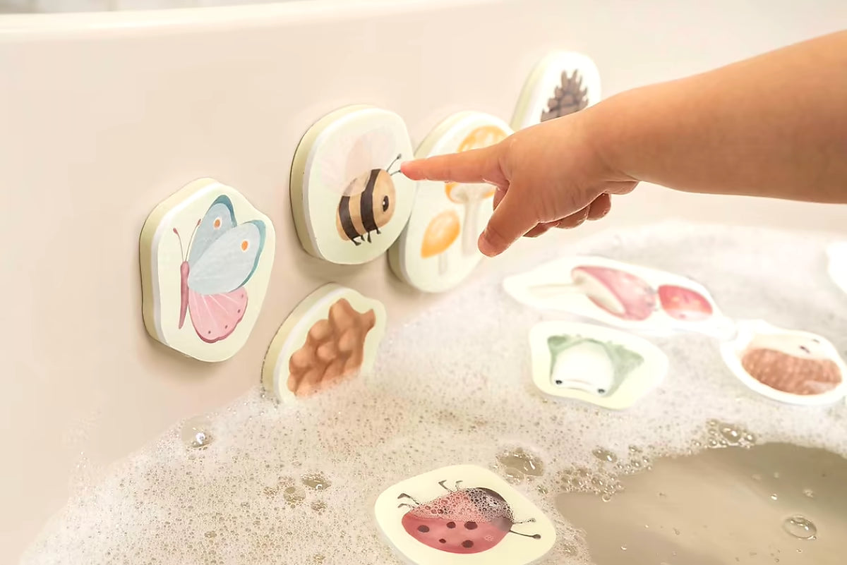 Little Dutch Bad Foam Figuren Forest Friends kind wijst naar bij en vlinder op badrand, kleurrijk badspeelgoed voor peuters.