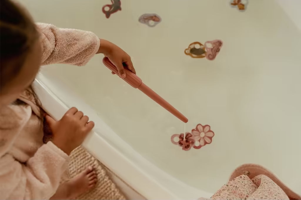 Kind vist een bloemvormig stuk uit het water met hengel uit Little Dutch badspeelgoed visspel Girl set.