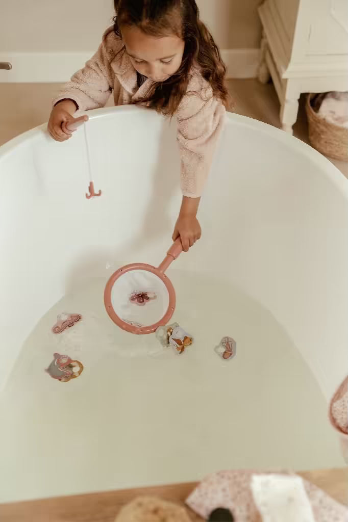 Kind gebruikt schepnet uit Little Dutch badspeelgoed visspel Girl om zeedieren te vangen in badwater.