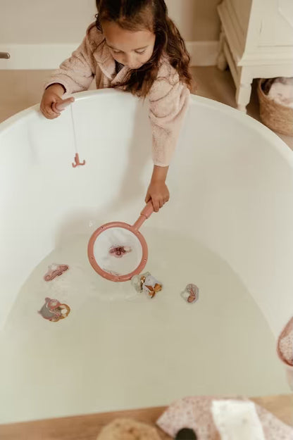 Kind gebruikt schepnet uit Little Dutch badspeelgoed visspel Girl om zeedieren te vangen in badwater.