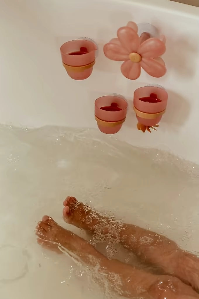 Kind speelt in bad met Little Dutch Badwand bekers bloem, stimulerend speelgoed voor in bad voor peuters.