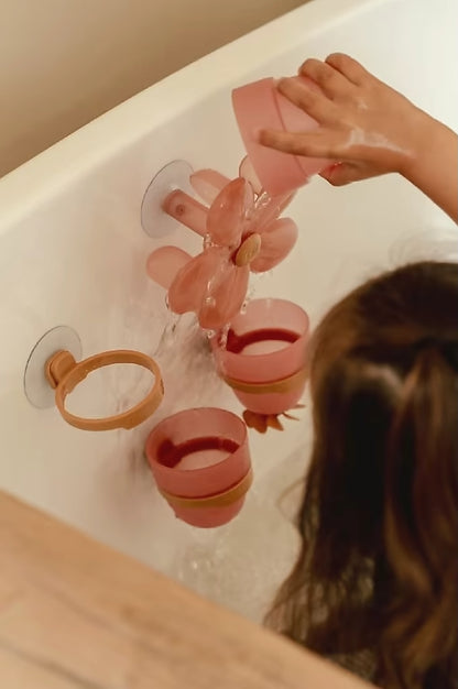 Peuter giet water in Little Dutch Badwand bekers bloem, interactief bad speelgoed dat water laat stromen.