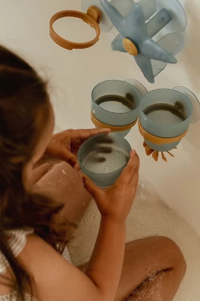 Peuter speelt met Little Dutch Badwand bekers zeester, blauwe bekers met zuignap en ster waterwiel in badwand set.
