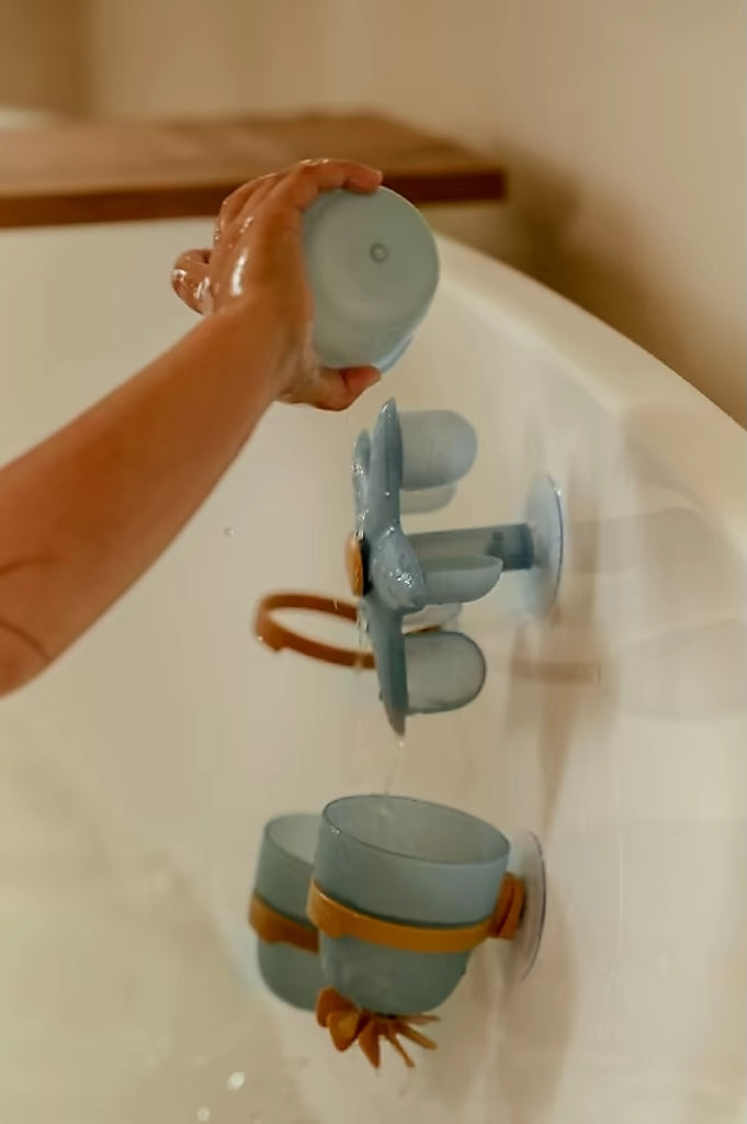 Water stroomt door Little Dutch Badwand bekers zeester, blauwe bekers en ster draaien door interactief bad speelgoed.