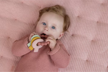 Baby ligt op roze kleed en speelt met Little Dutch Bijtring siliconen sleutels, ideaal baby cadeau.