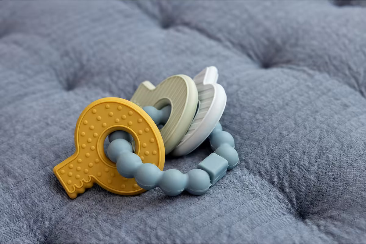 Close-up van Little Dutch Bijtring siliconen sleutelbos in blauw en pastelkleuren, duurzaam bijtspeeltje babyuitzet.