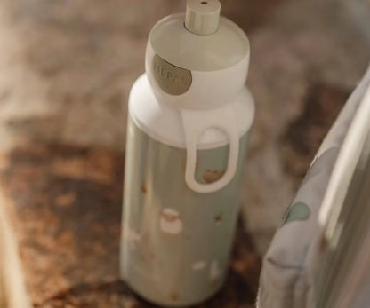 Little Dutch drinkfles Mepal in groen met handige draaglus, afgebeeld buiten op een bank, perfect als drinkfles kind.