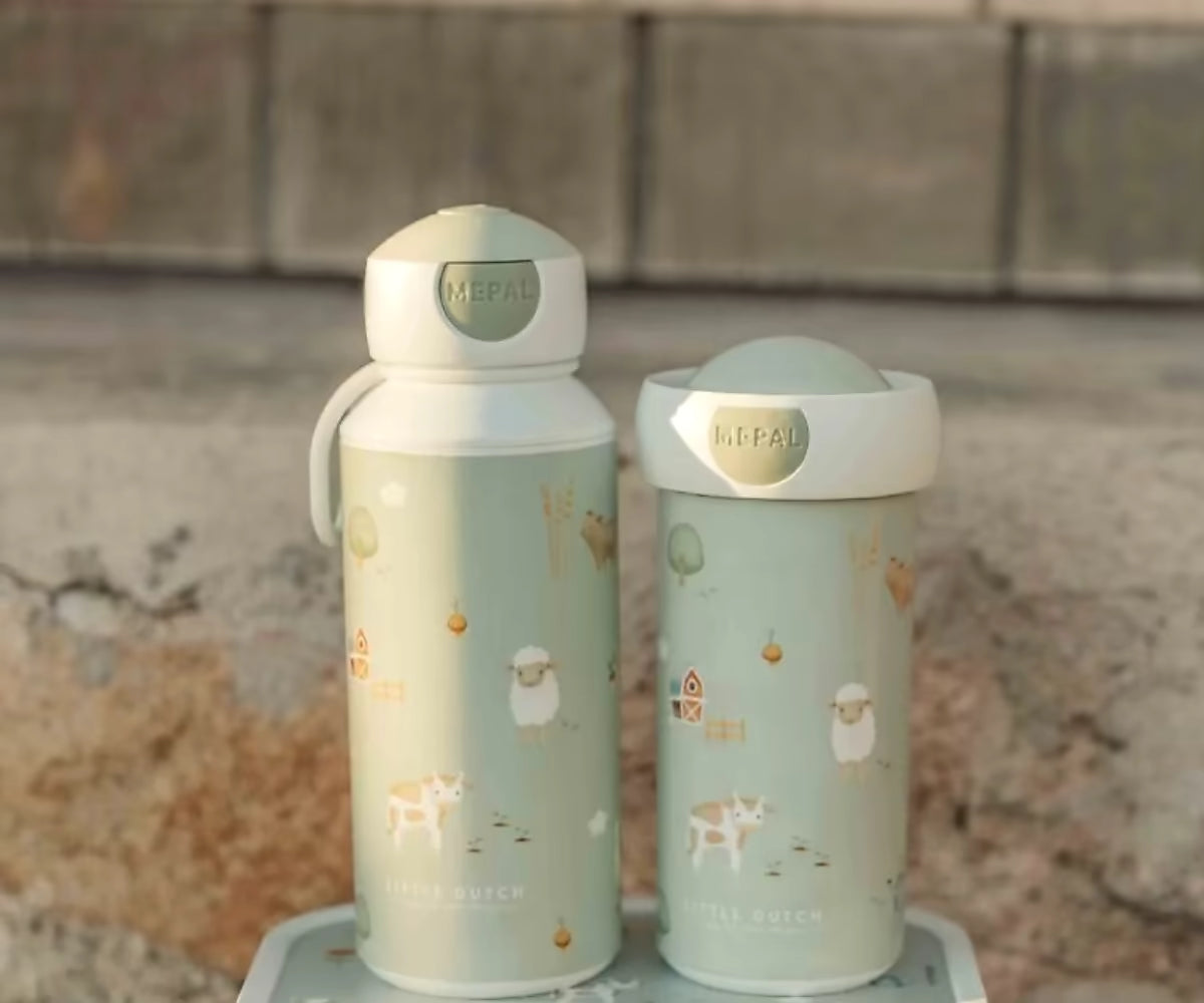 Little Dutch drinkfles Mepal Little Farm set met boerderijdieren, twee varianten naast elkaar in buitenomgeving.
