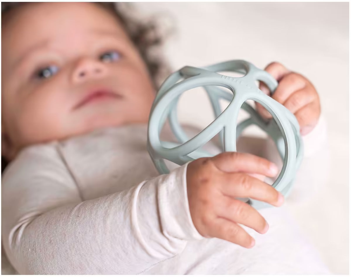 Baby speelt met Little Dutch Grijpbal blauw, licht en flexibel sensorisch speelgoed voor motorische ontwikkeling.