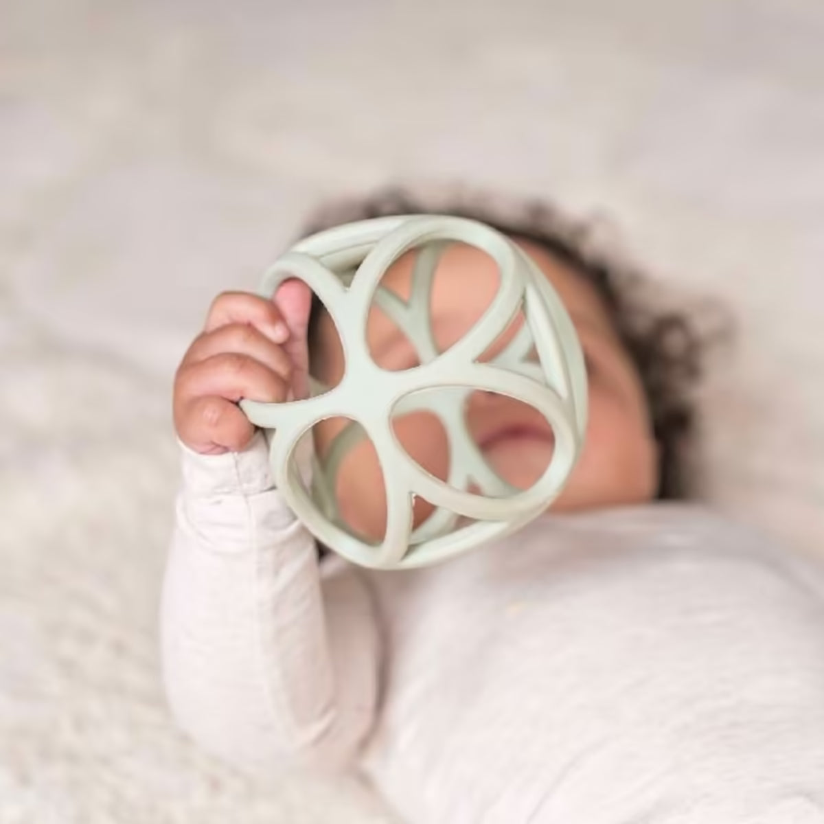 Baby ontdekt met handjes de Little Dutch Grijpbal Groen, een flexibel bijtspeeltje en leuk speelgoed.