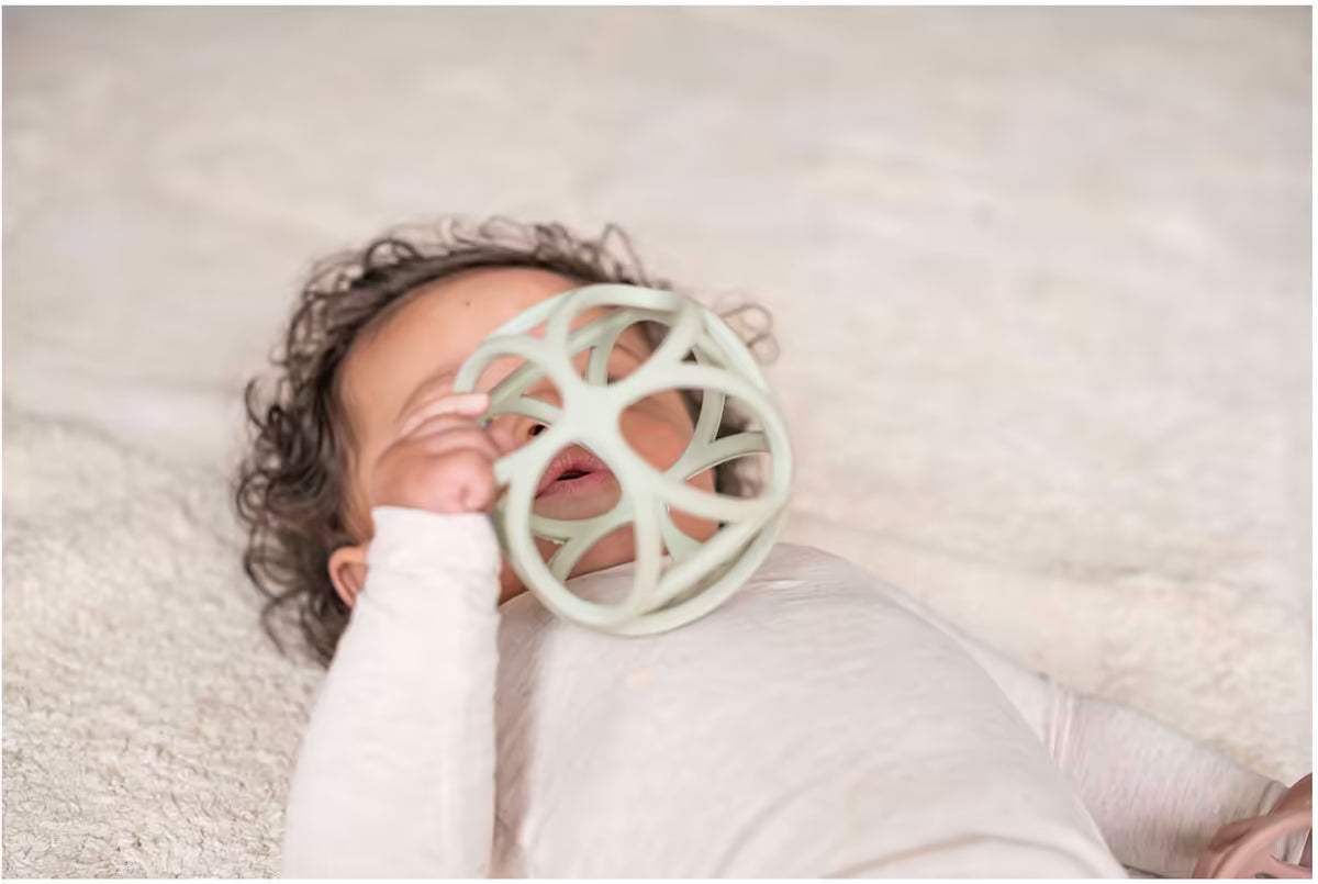 Baby speelt met Little Dutch Grijpbal Groen, licht sensorisch speelgoed dat stimuleert bij grijpen en ontdekken.