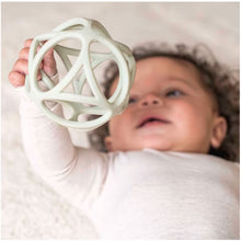 Blije baby houdt Little Dutch Grijpbal Groen vast, ideaal als bijtring baby en stimulerend babyspeelgoed.