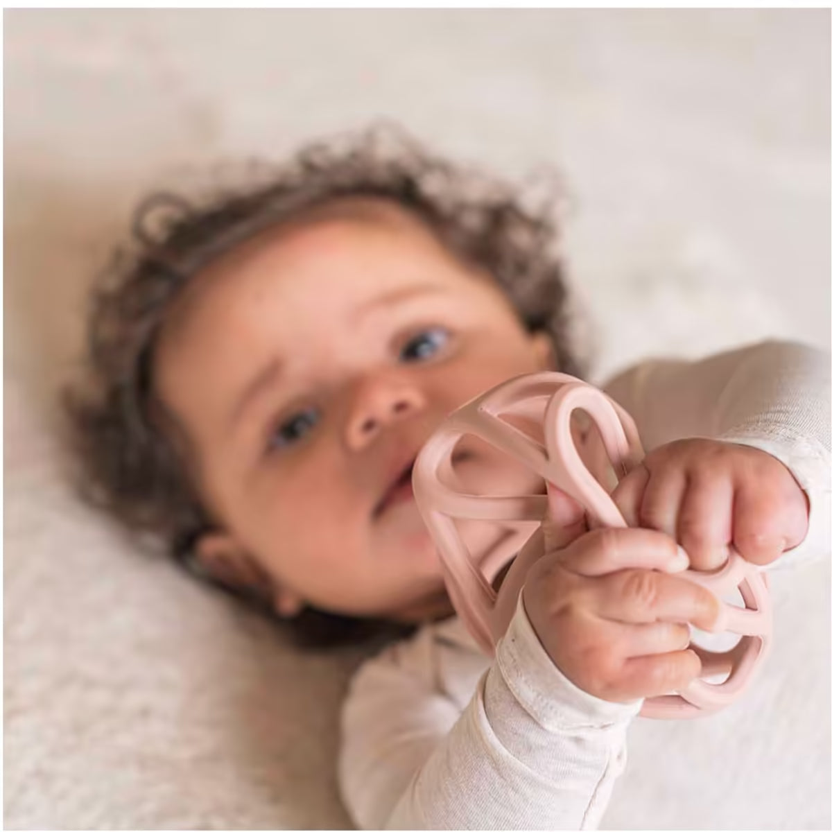 Baby speelt met Little Dutch Grijpbal roze, stimulerend sensorisch speelgoed voor de motoriek vanaf 4 maanden.