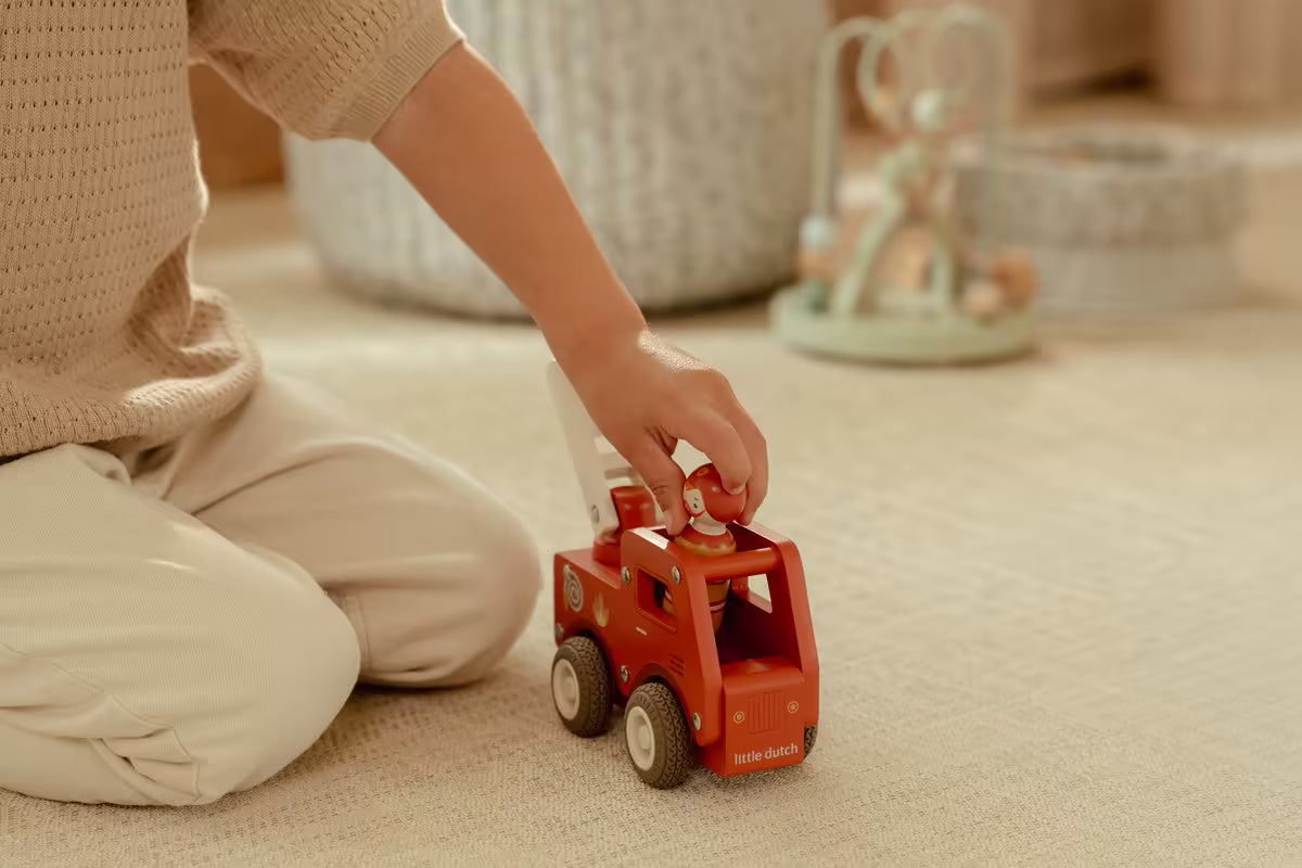 Peuter speelt met Little Dutch houten brandweerwagen en pegdoll, stevig speelgoed hout voor jonge kinderen.