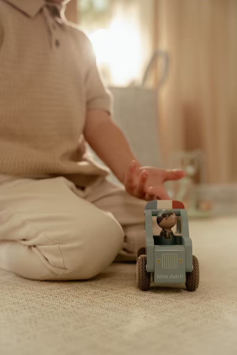 Peuter rijdt met Little Dutch houten politiewagen, baby speelgoed geschikt als duurzaam baby cadeau.