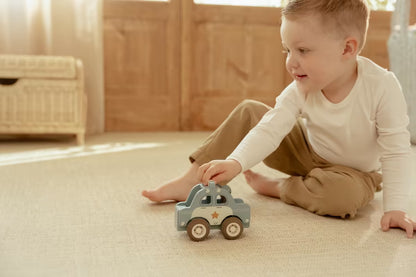 Jongetje speelt met Little Dutch houten politiewagen, stevig speelgoed hout voor peuters en baby speelgoed.