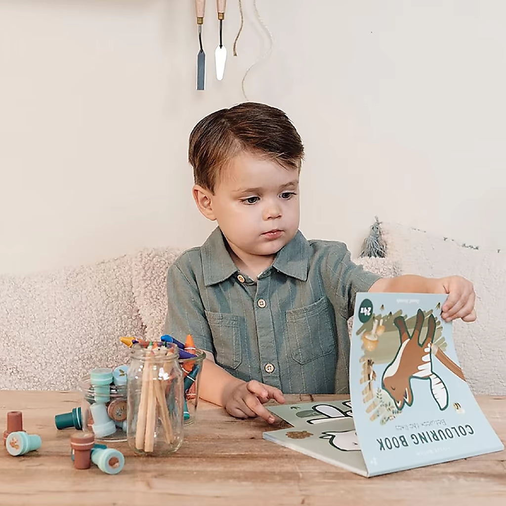 Peuter bladert in Little Dutch kleurplaat Forest Friends kleurboek met dieren kleurplaten op houten tafel.