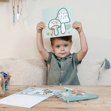 Blij kind toont ingekleurde paddenstoelen uit Little Dutch kleurplaat Forest Friends met schattige dieren kleurplaat.