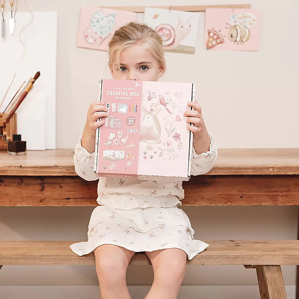 Kind houdt de Little Dutch Knutseldoos Fairy Garden verpakking vast, ideaal cadeau voor knutselen met peuters thuis.
