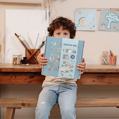 Peuter houdt Little Dutch Knutseldoos Forest Friends verpakking vast, ideaal voor knutselen met peuters thuis.