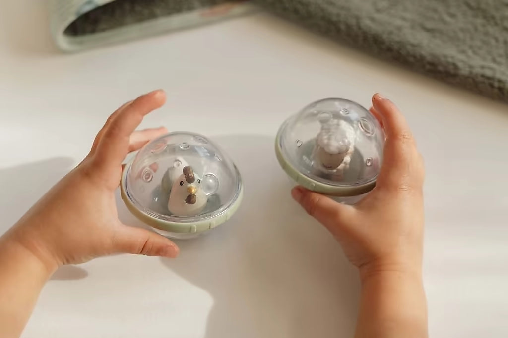 Little Dutch Roterende Ballen Farm met kip en schaap vastgehouden door kind, interactief peuter speelgoed voor bad.