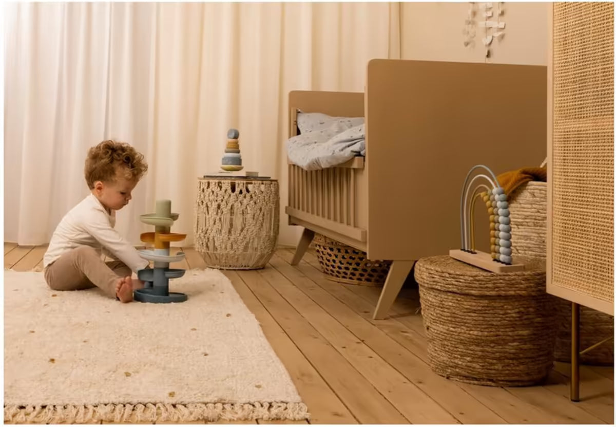Kind speelt met Little Dutch Spiraaltoren Blauw in een warme babykamer, ideaal als baby cadeau of cadeau 1 jaar.