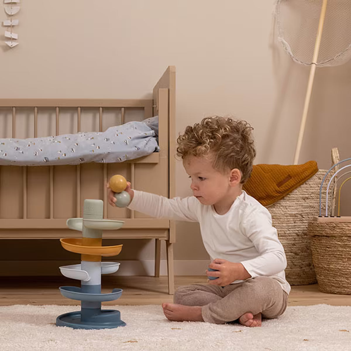 Peuter speelt met Little Dutch Spiraaltoren Blauw in een kinderkamer, een ideaal cadeau 1 jaar.