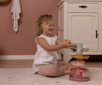 Peuter speelt lachend met de Little Dutch Spiraaltoren Roze, montessori speelgoed dat zorgt voor leerzaam speelplezier.