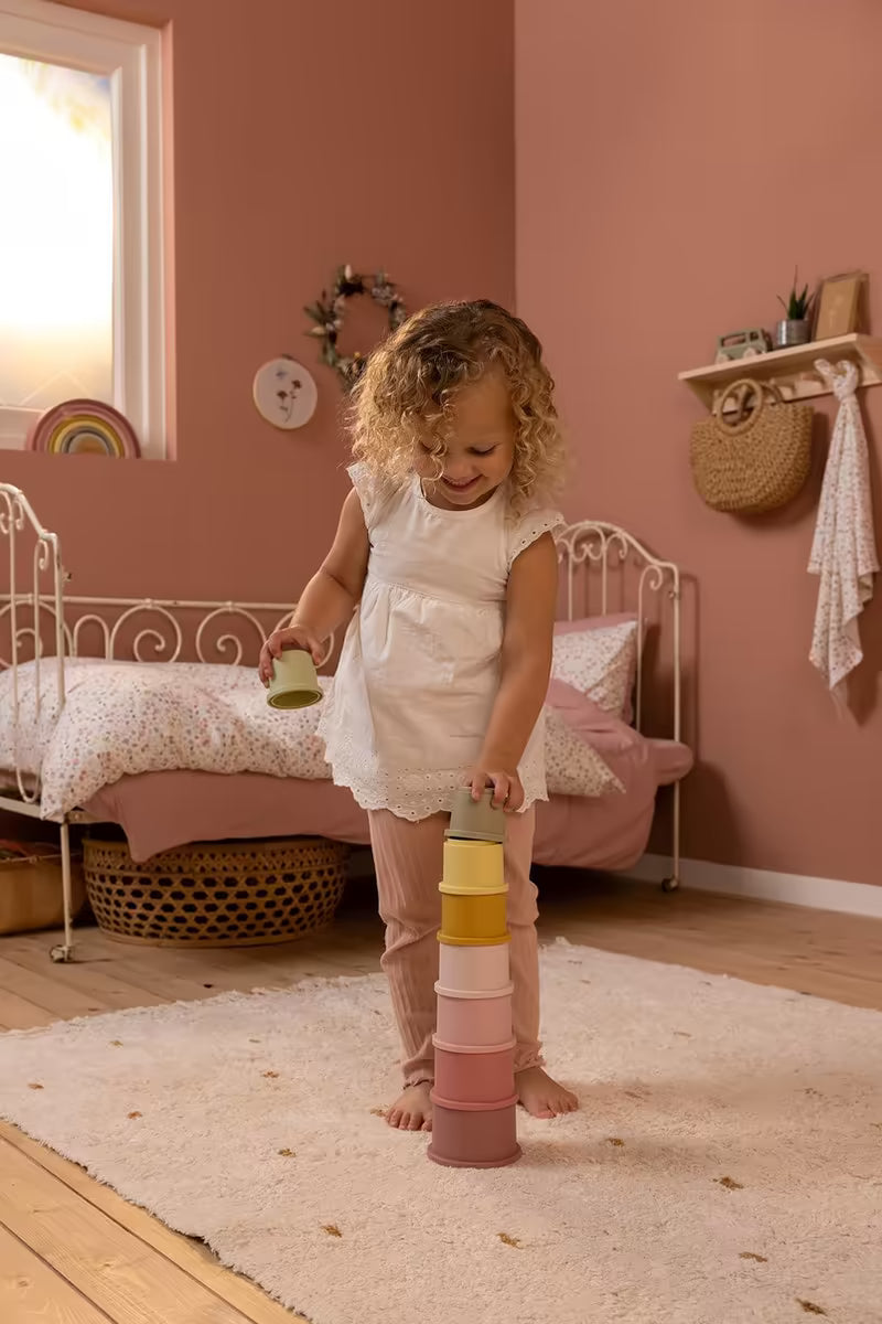 Peuter speelt met Little Dutch Stapelbekers - Roze, duurzaam Montessori speelgoed voor educatief leren en plezier.