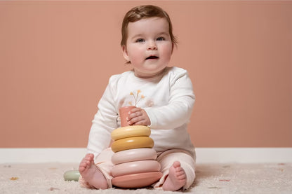 Baby houdt Little Dutch Stapelringen Roze vast, ideaal baby cadeau dat spelenderwijs leren stimuleert.