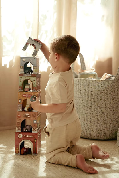 Kind bouwt met Little Dutch Stapeltoren en houten auto’s, educatief speelgoed dat ook sensorisch speelgoed is.