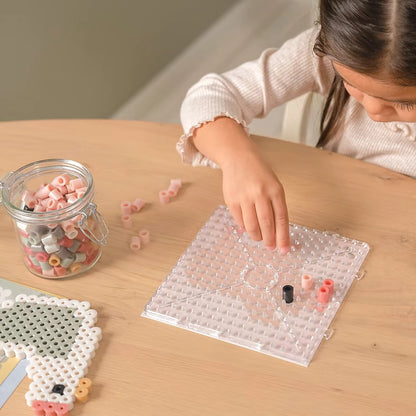 Peuter begint een creatie op strijkplaat met Little Dutch Strijkkralen Maxi, eenvoudig strijkkralen strijken voor kinderen.